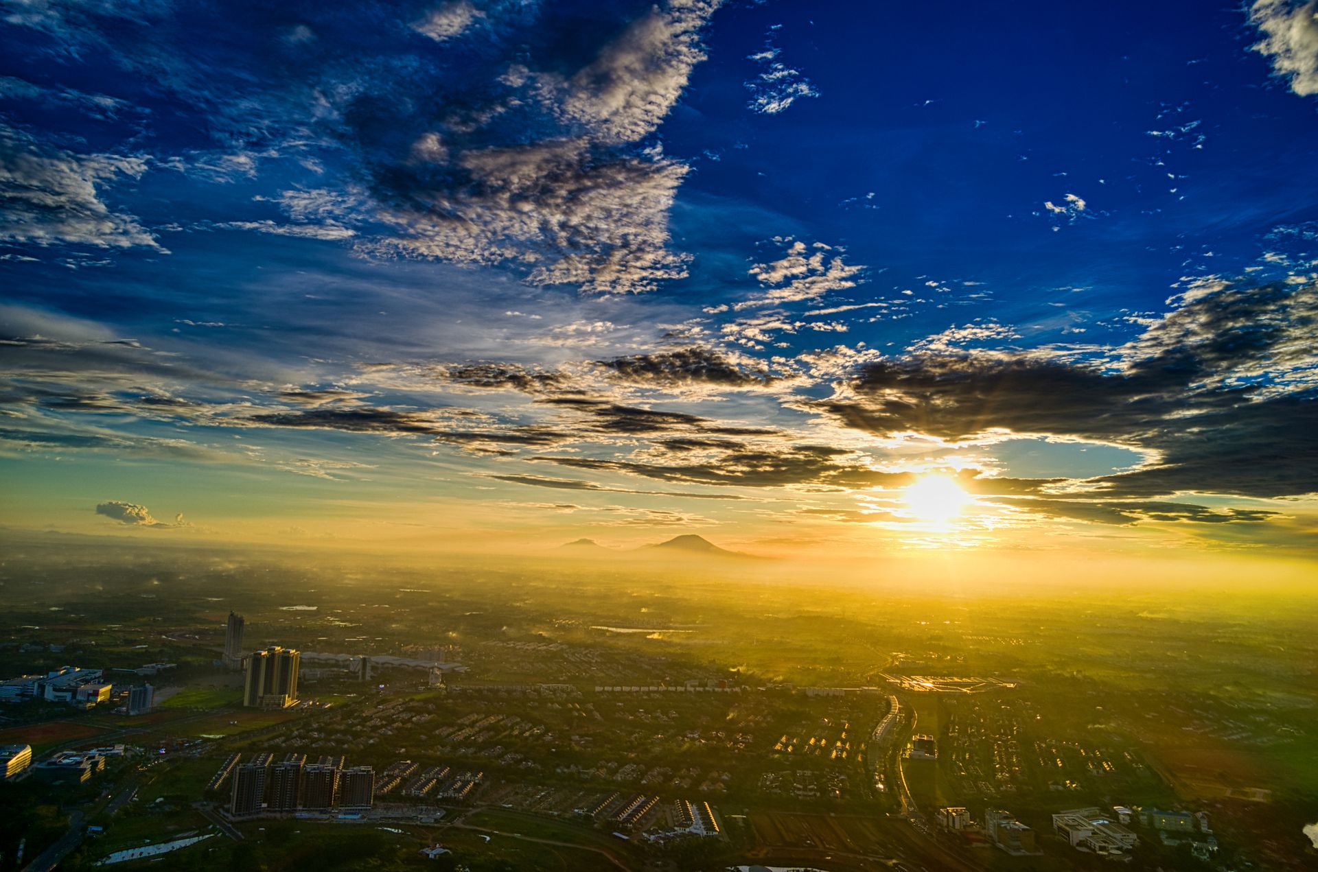 Drone shot of sunrise over Banten, Indonesia, capturing cityscape and vibrant sky.