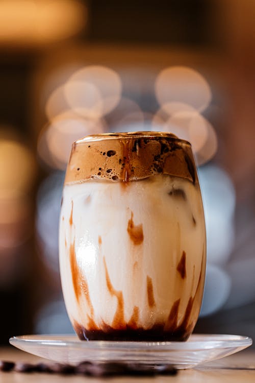 A glass of iced coffee with a brown swirl