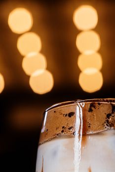 Close-up of a creamy iced coffee with a soft bokeh background, showcasing rich textures.