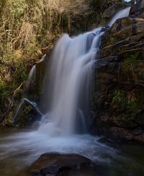 Free Captivating waterfall cascading through a lush forest landscape, perfect for nature lovers. Stock Photo