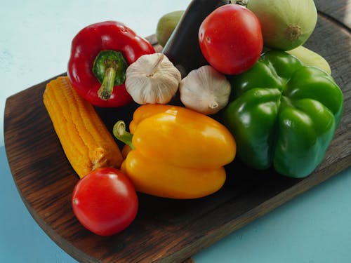 A wooden cutting board with vegetables on it