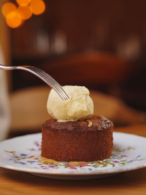 Free Close-up of a chocolate brownie topped with vanilla ice cream on a decorative plate. Stock Photo