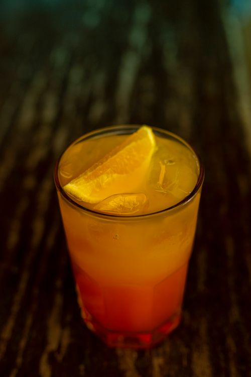 Free A chilled orange juice served in a glass with ice cubes and a slice of orange. Stock Photo