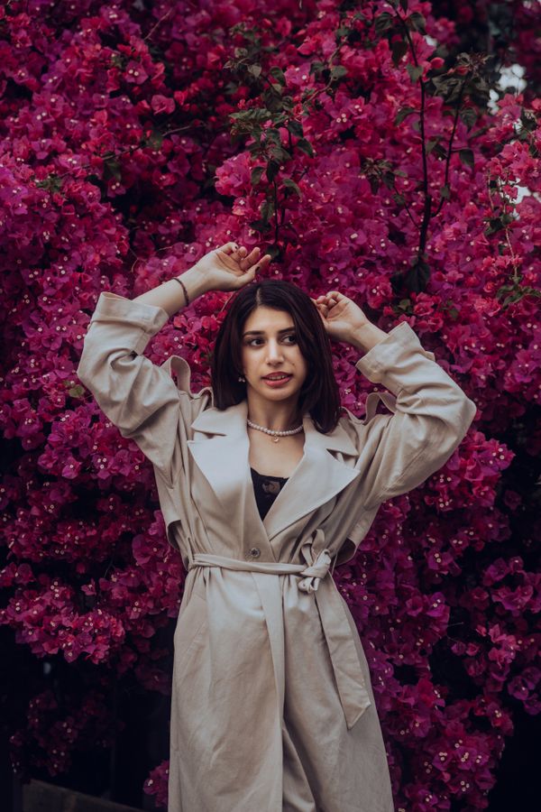 Woman in a cream trench coat over a slip dress on a city street