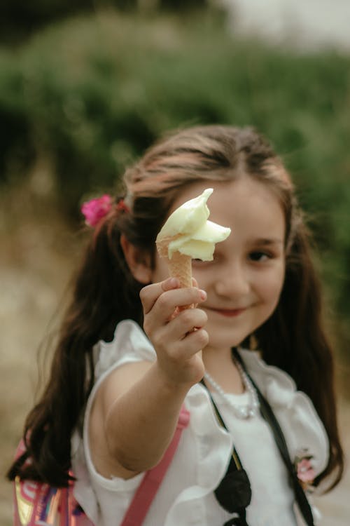 A little girl holding up an apple