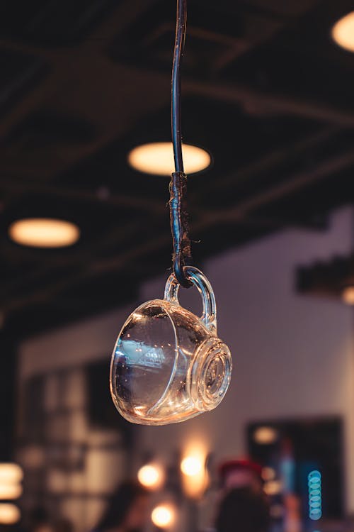 A glass coffee cup hanging from a cord in a restaurant