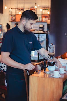A barista skillfully operates a coffee siphon in a trendy café setting.