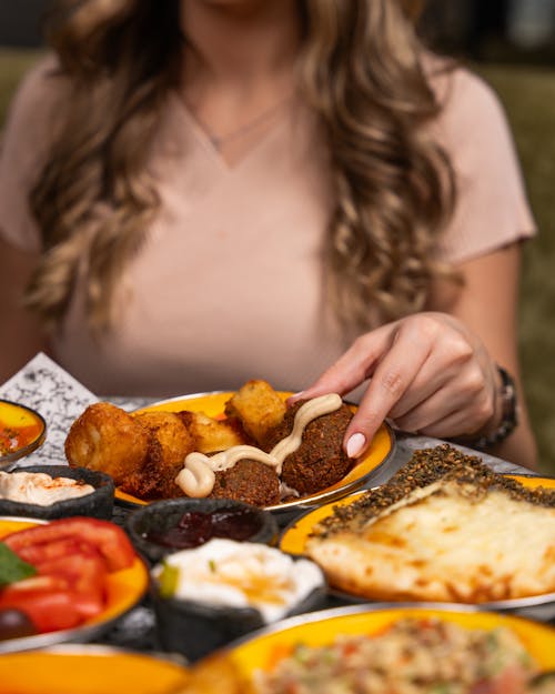 A woman is holding a plate of food with a variety of different foods