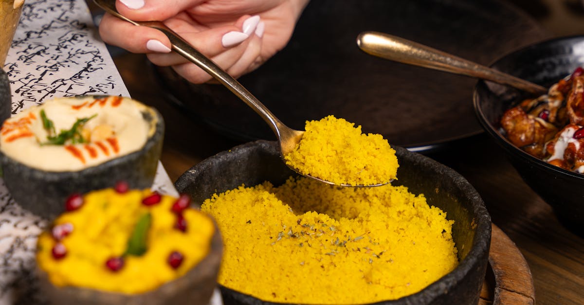 Different varieties of Valencian rice grains displayed on a wooden table.