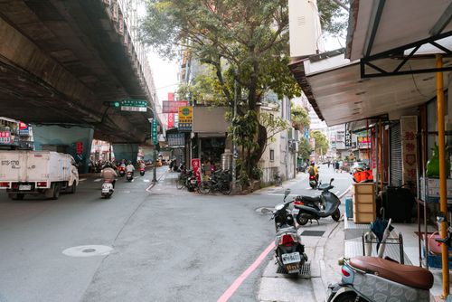 Free Busy urban street in Asia with scooters, motorbikes, and urban infrastructure. Stock Photo