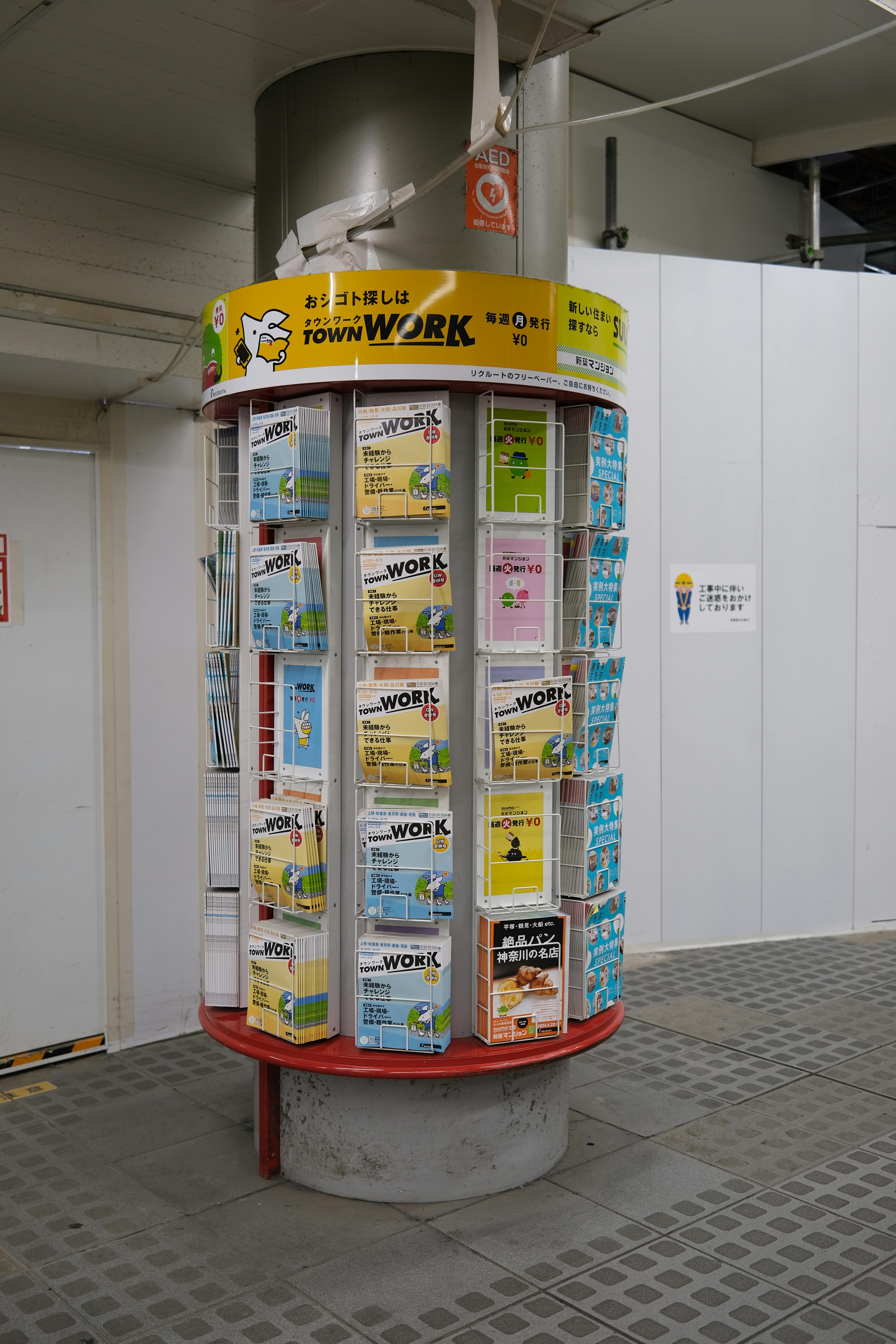 A vertical advertisement booth with various flyers in Shinagawa, Tokyo.