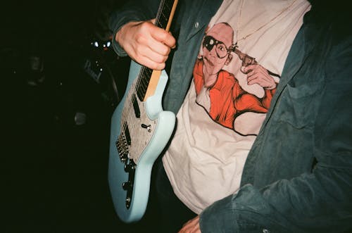 Person Carrying Blue Electric Guitar