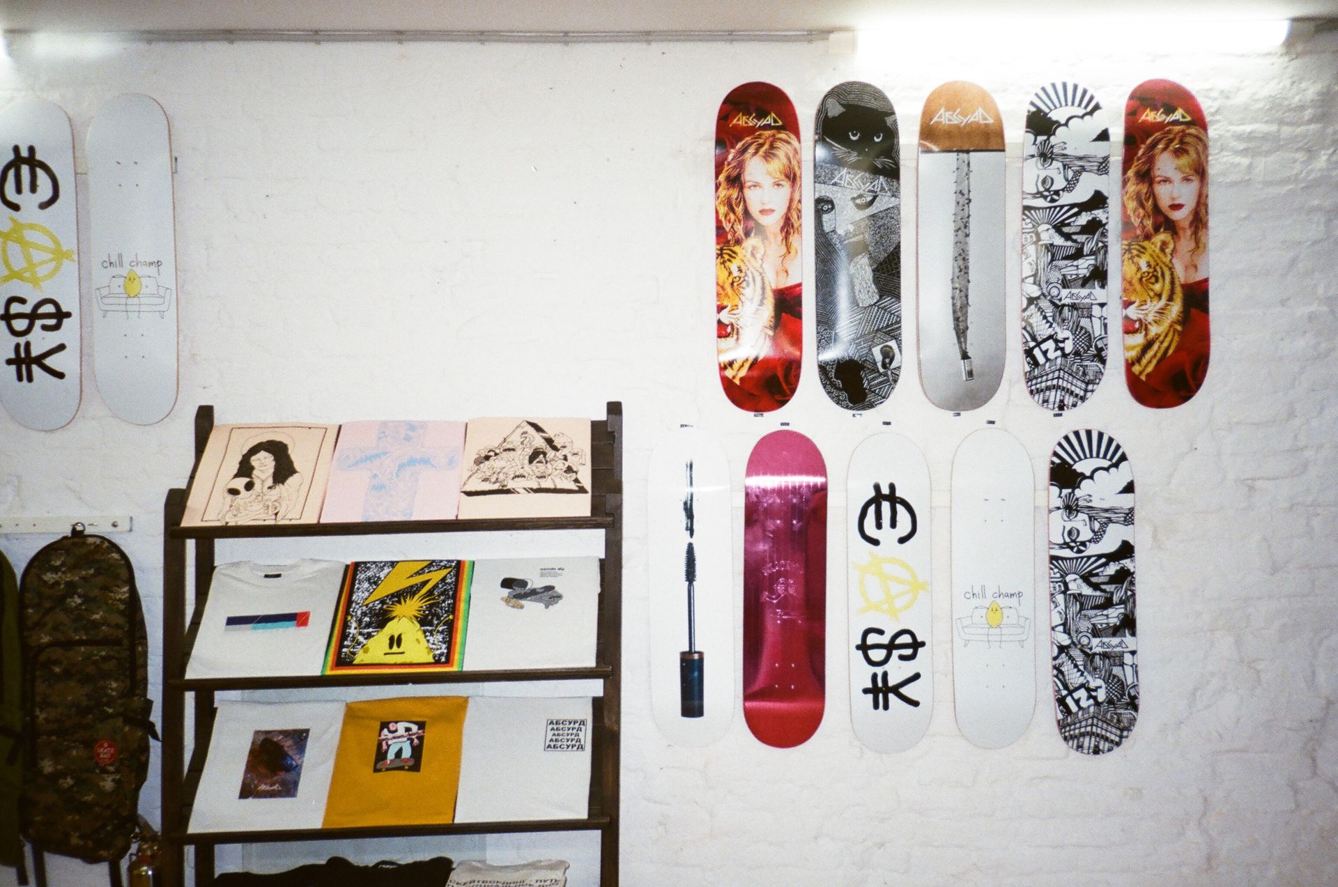 Colorful artistic skateboard decks displayed on white brick wall