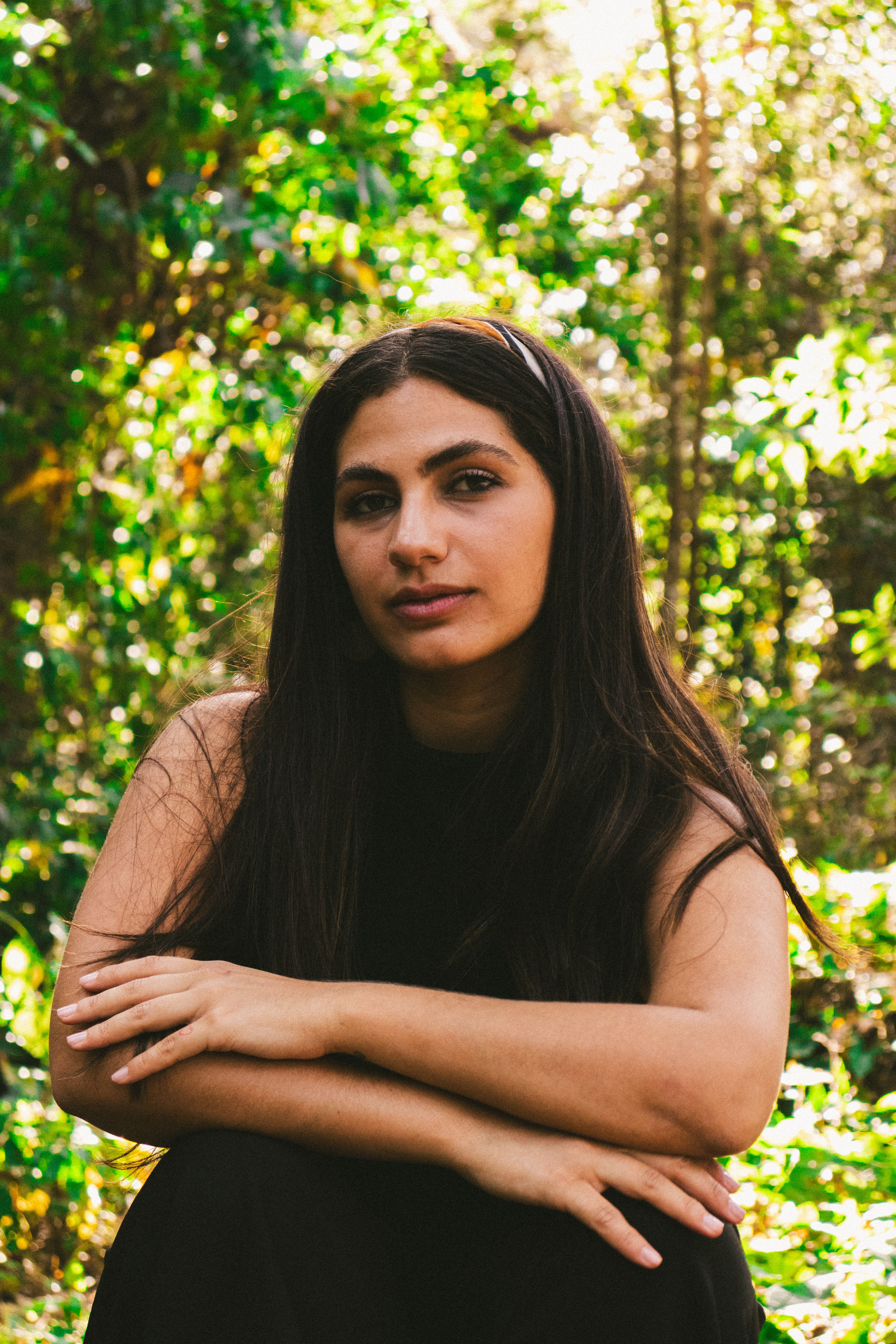 A serene portrait of a woman surrounded by lush greenery in a Florida forest.