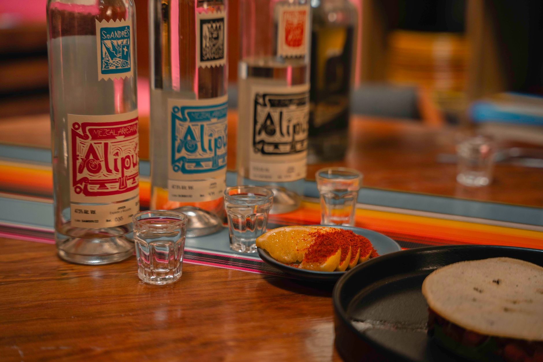 Close-up of pouring pure tequila into a shot glass