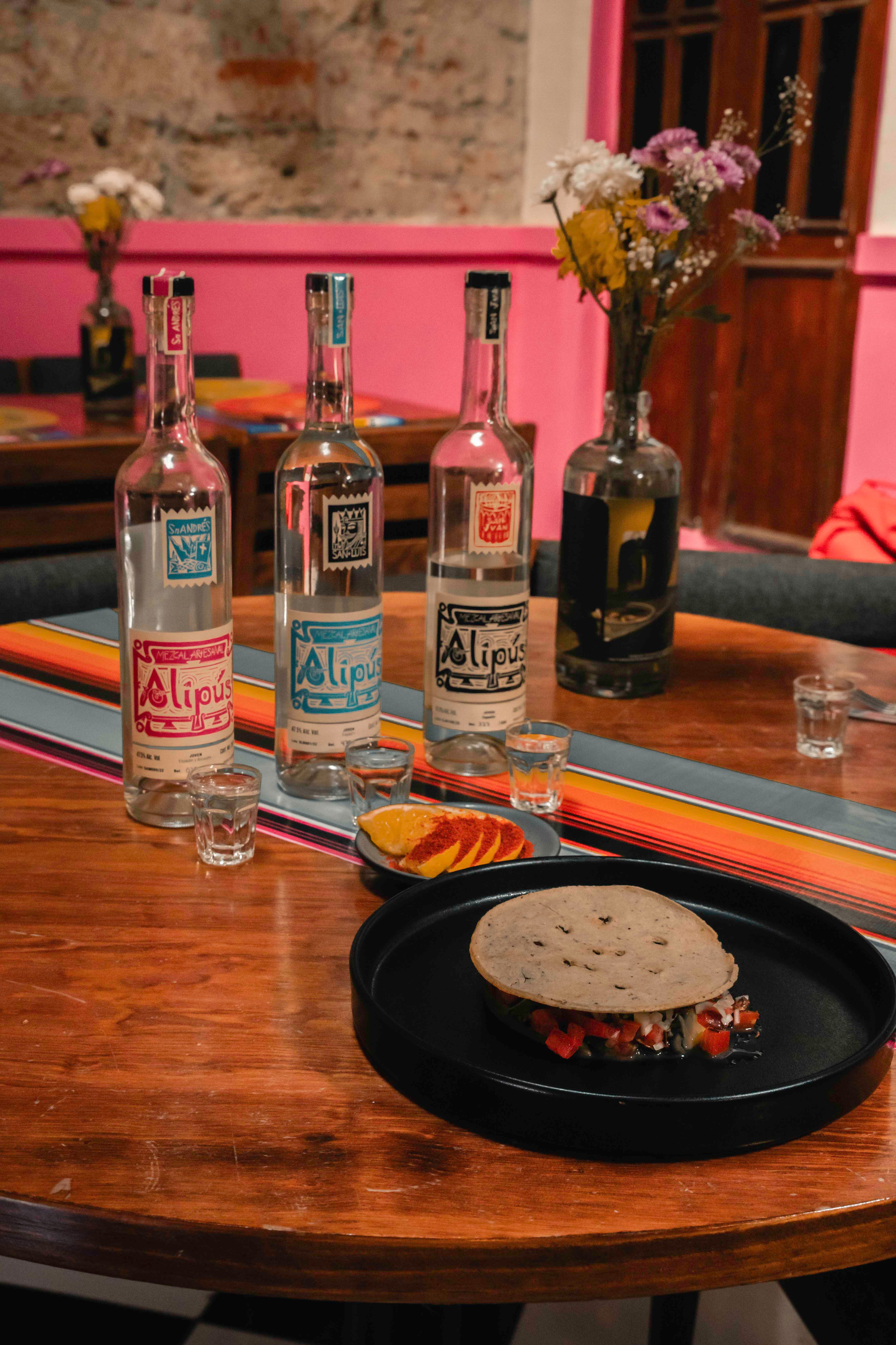 A table with three bottles of alcohol and a plate of food · Free Stock ...