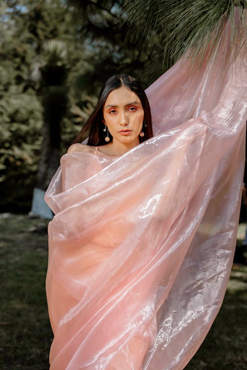 A woman in a pink sari holding a veil