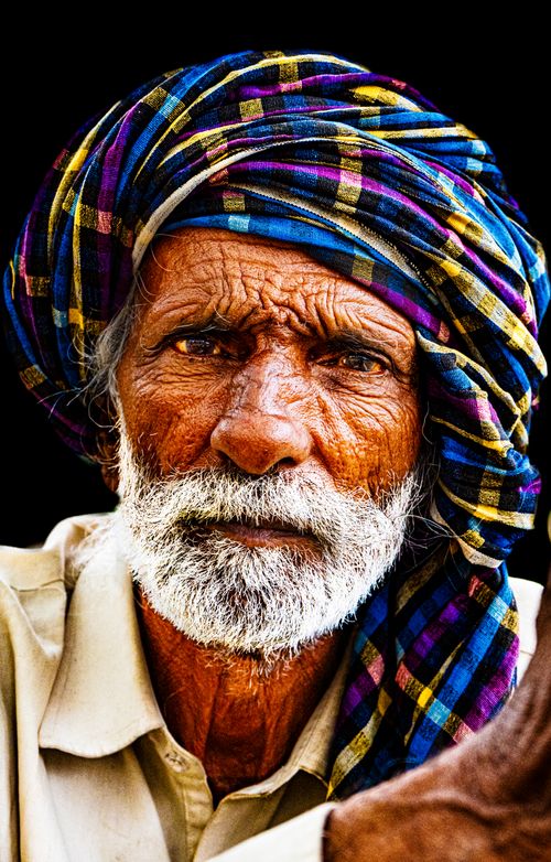 Free Close-up of an elderly man with a turban, showcasing deep wrinkles and vibrant colors. Stock Photo