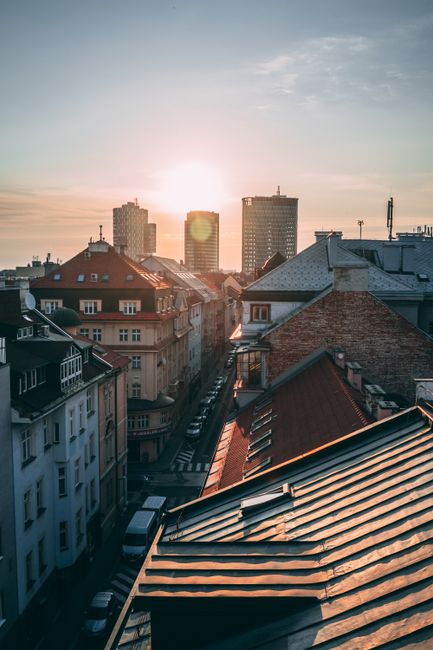 Stunning view of Bratislava's urban skyline at sunset with historic and modern buildings.