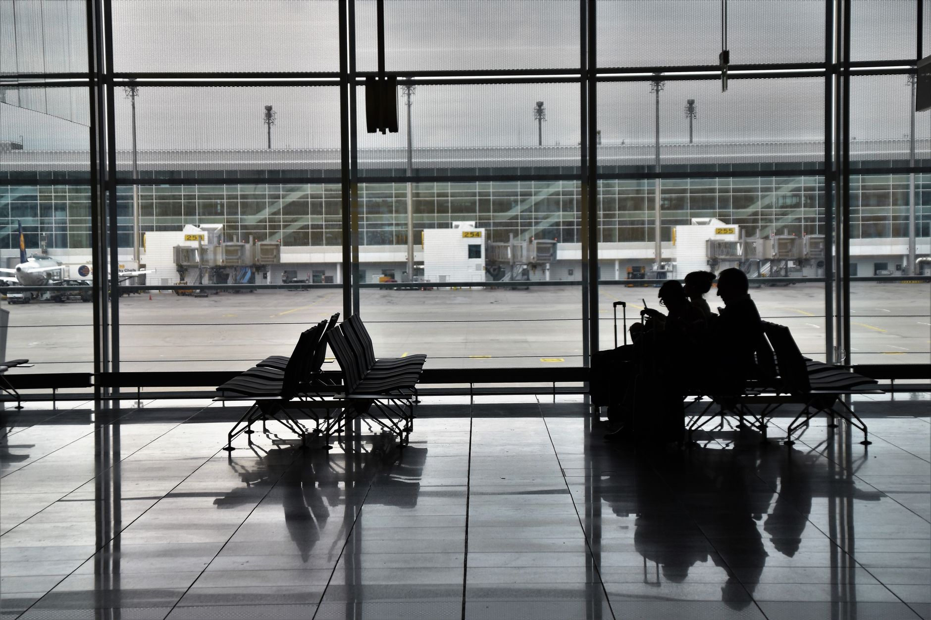 Quiet Airport Terminal A wide shot of a modern, clean airport terminal with very few people, showcasing empty check-in counters and departure gates during an off-peak travel period.