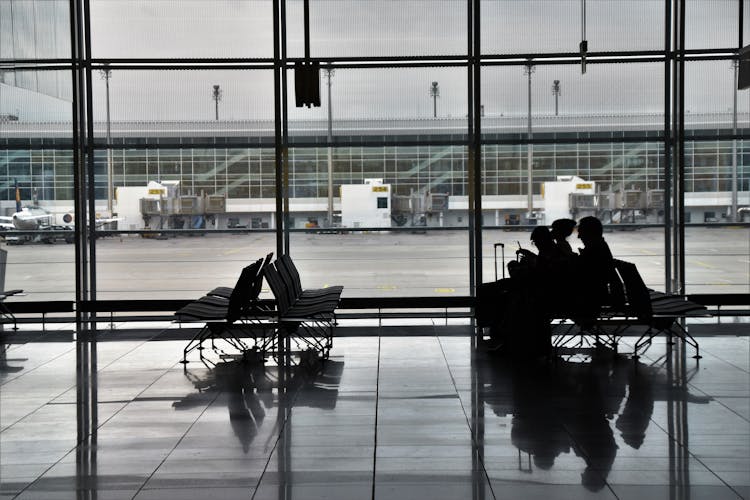 People Sitting On Chairs In Airport