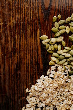 特写镜头聚焦于乡村木质表面的燕麦和南瓜子，突出其纹理与自然色彩