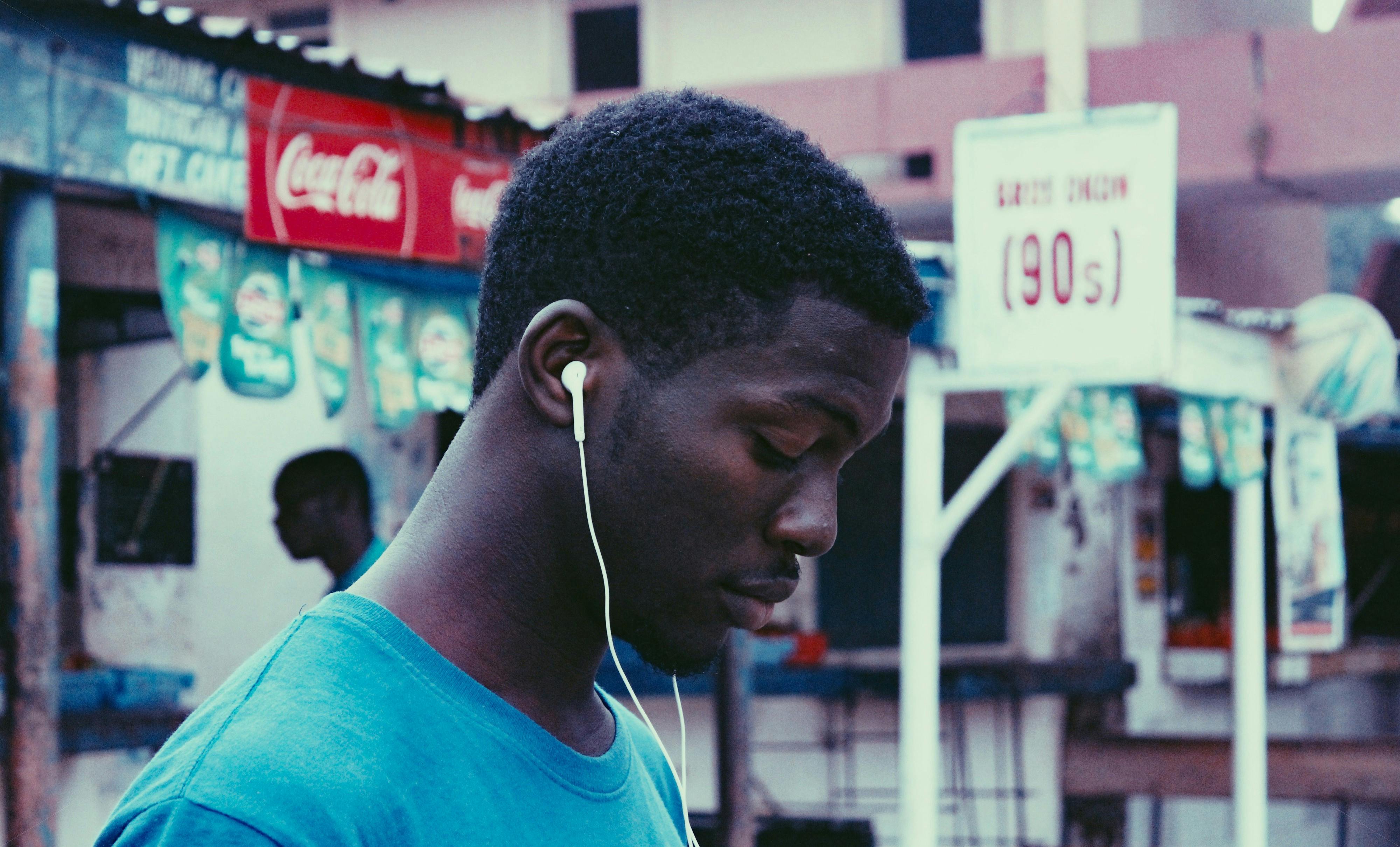 man using earphones near store