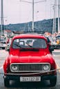 在克罗地亚贝拉卢卡，一辆经典的红色雷诺4汽车停在游艇背景前