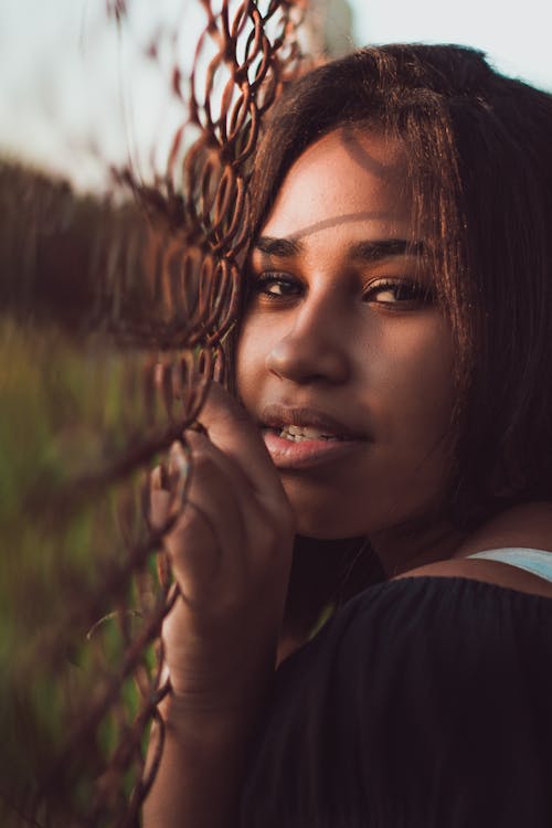 Woman Portrait Holding On Cyclone Fence