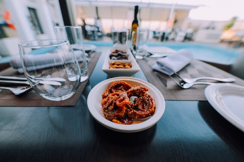 Cooked Food on Bowl Beside Drinking Glass on Table