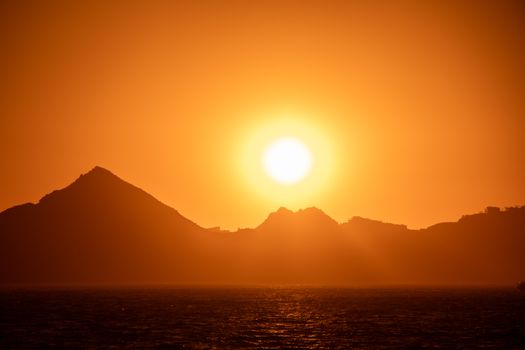 Experience a breathtaking sunset over Cabo San Lucas with striking silhouettes of the Baja California Sur mountains.