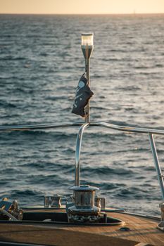 Close-up of a yacht's deck railings with ocean view in Cabo San Lucas, México at sunset.