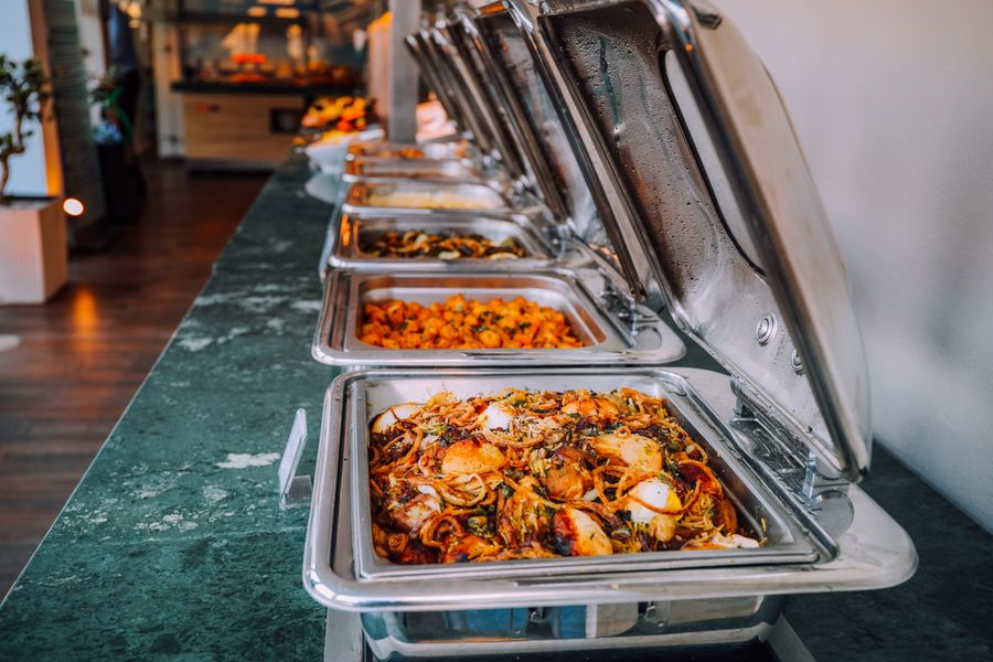 Elegant buffet setup with dishes in stainless steel chafing dishes for events