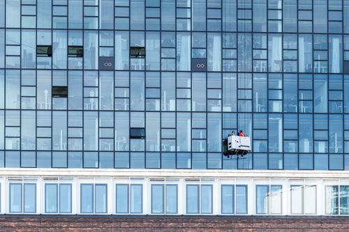 Free High-rise glass facade with cleaning platform and workers in Hamburg, Germany. Stock Photo