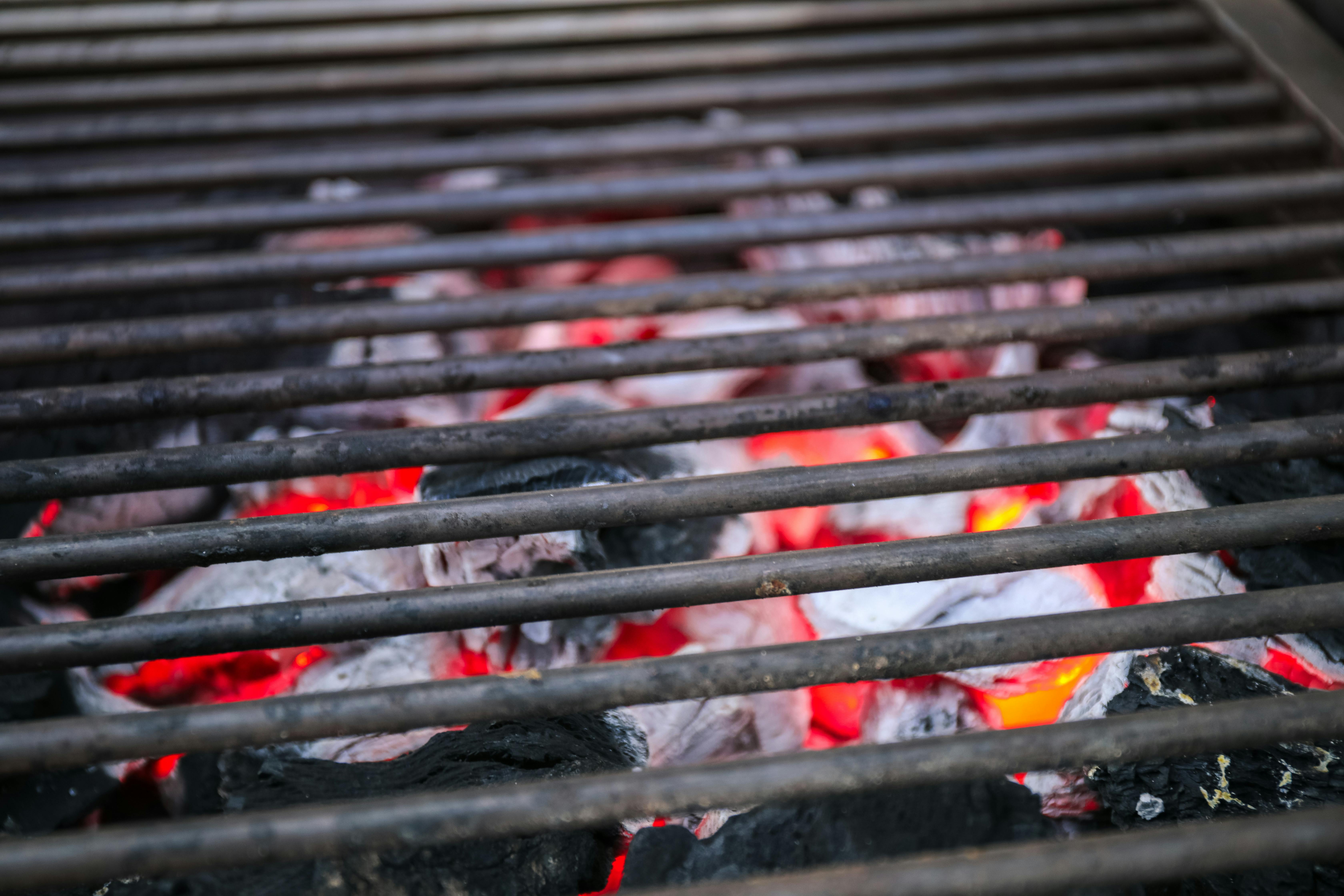 Couple walking down a wedding aisle lined with guests holding up phones