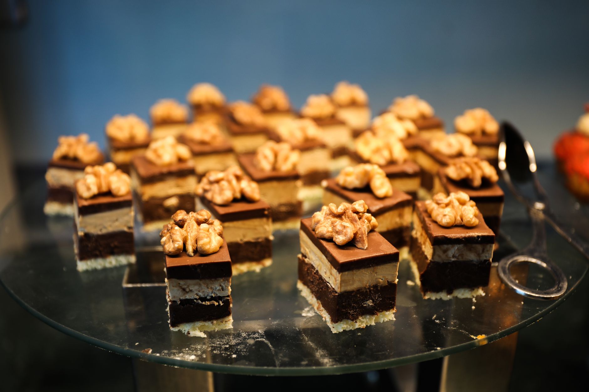 A mouth-watering assortment of chocolate walnut pastries arranged on a glass platter, perfect for indulgence.