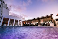 屋顶游泳池充满活力，日落时分的用餐体验装饰优雅，环境照明宜人