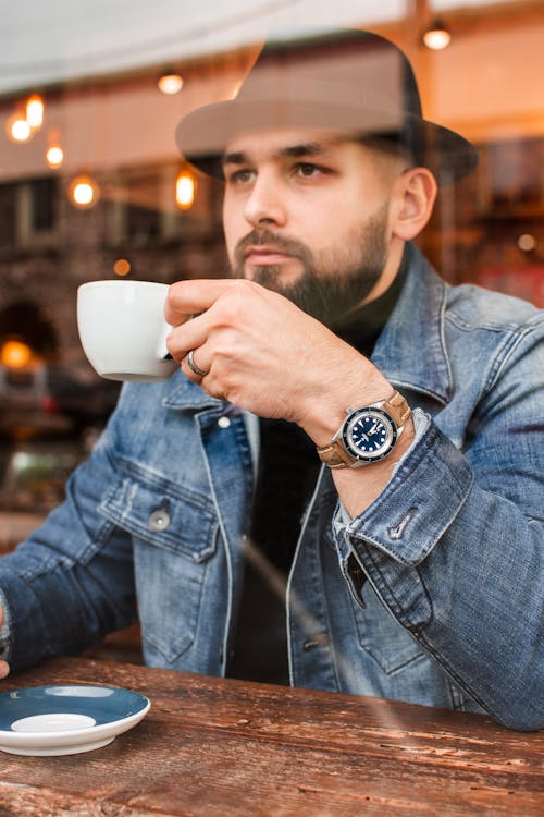 Free Photo of Man Sitting While Holding Cup Stock Photo