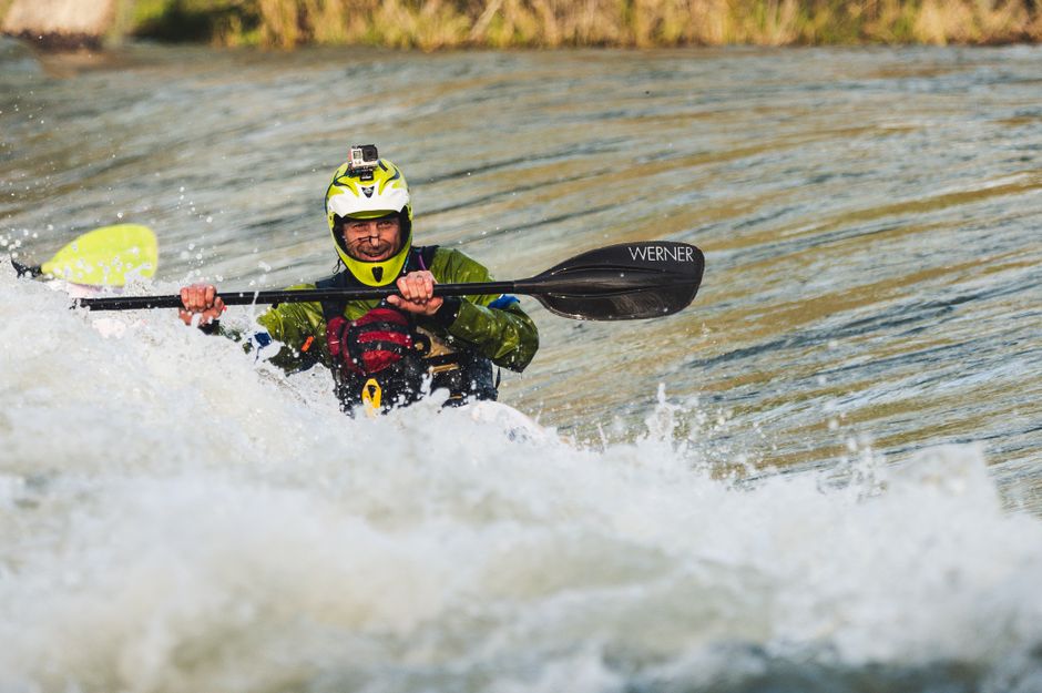 A kayaker skillfully navigates rapids, showcasing extreme water sports action.