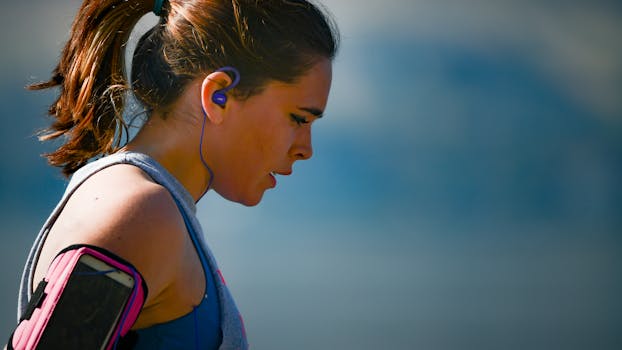 A determined female athlete running in Chelan, WA with earphones, captured in a side profile.