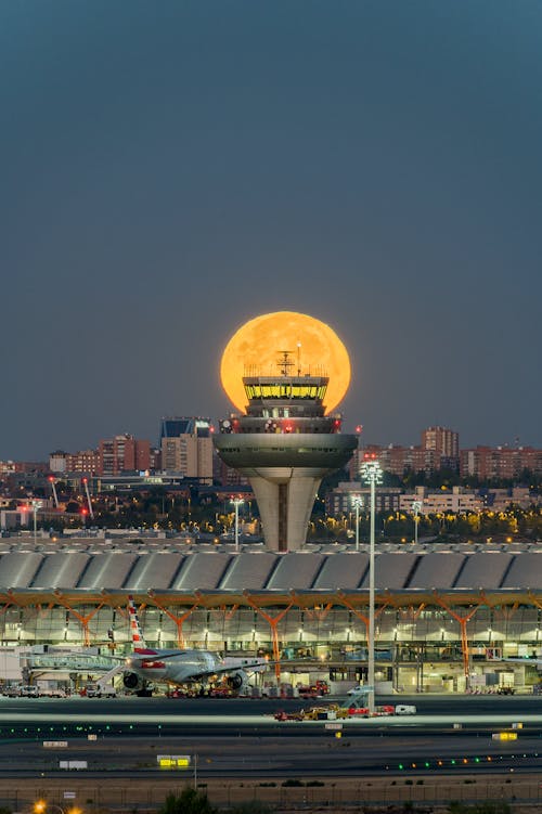Free Full Moon behind Air Traffic Control at Madrid Airport Stock Photo