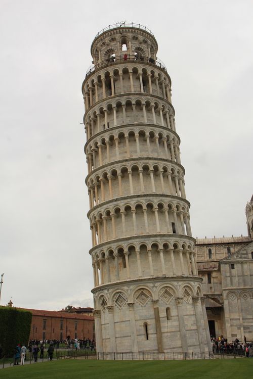 Free The famous Leaning Tower of Pisa in Italy captured on a cloudy day, showcasing its unique tilt. Stock Photo