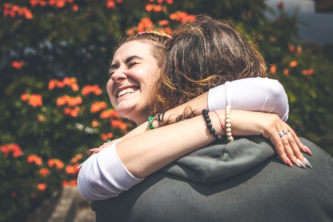 Free Smiling Woman Hugging Another Person Stock Photo