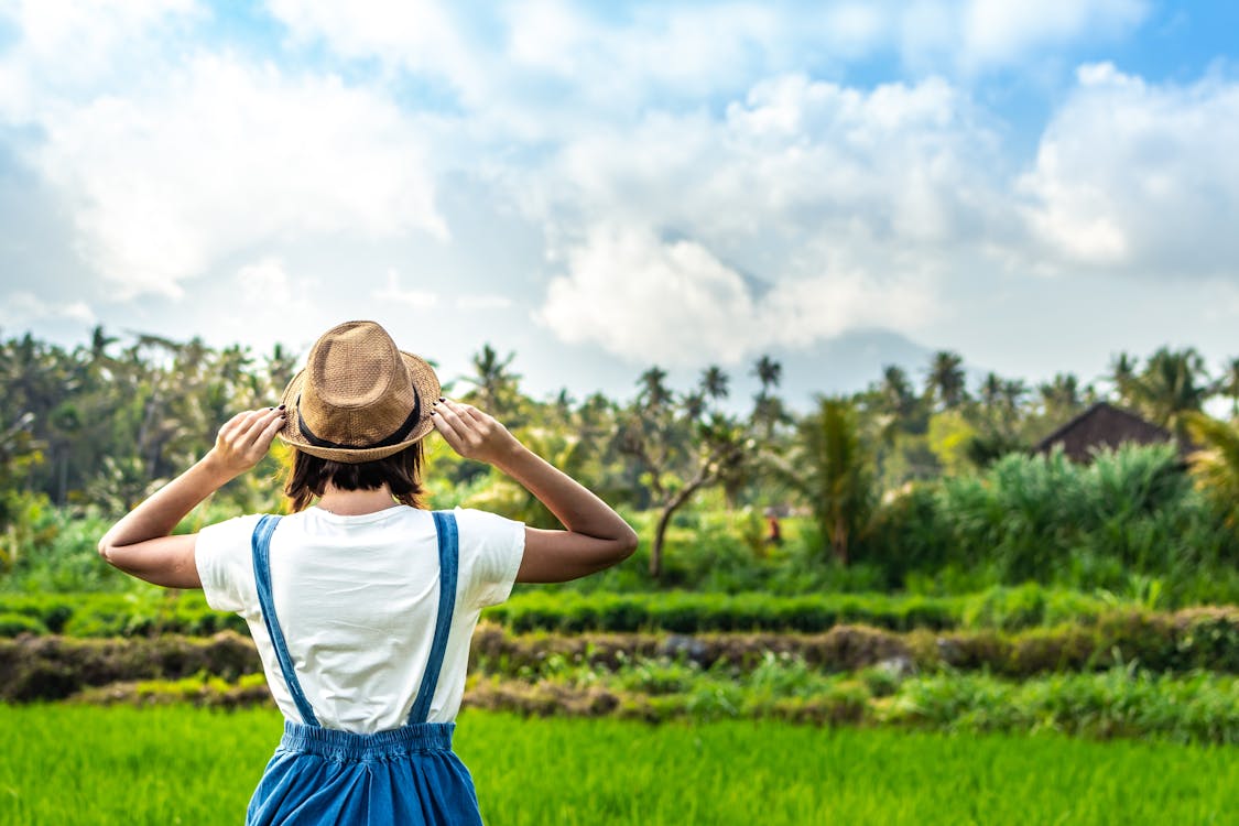 Free Woman Standing in Front of Green Field Stock Photo