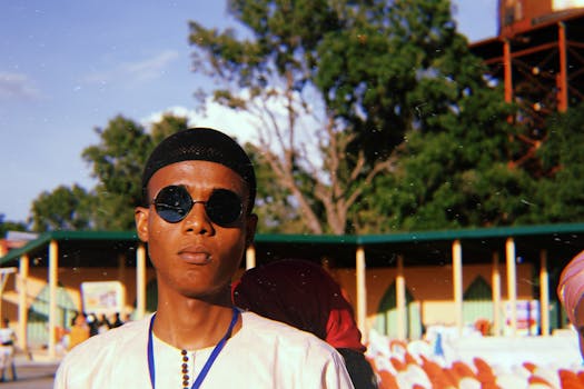 一位自信的年轻人戴着墨镜，在户外活动中摆出姿势，拥抱阳光明媚的一天