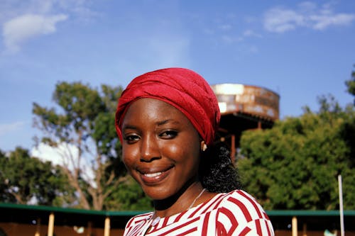 Portrait Photo of Smiling Woman in Maroon Headscarf