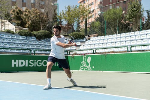 A man is playing tennis on a court