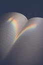 Empty opened diary with blank pages and reflection of bright rainbow light on surface
