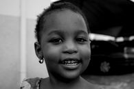 Black and white image of a smiling child showing innocence and joy.