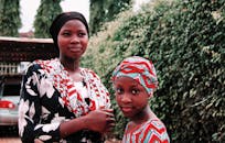 一对非洲姐妹身着传统服装，在户外拍摄的美丽肖像